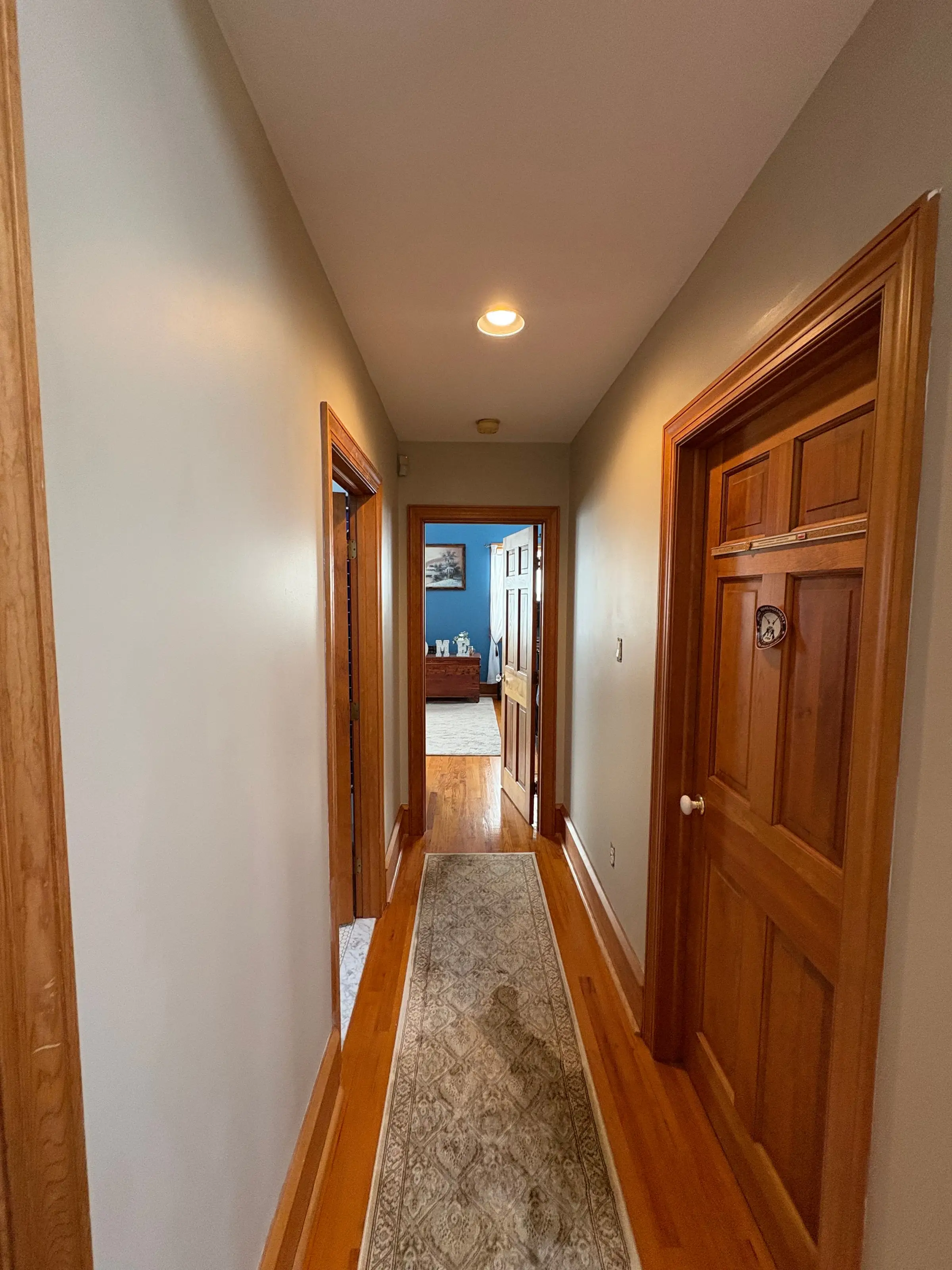 Freshly painted interior hallway with stained wood door and trim