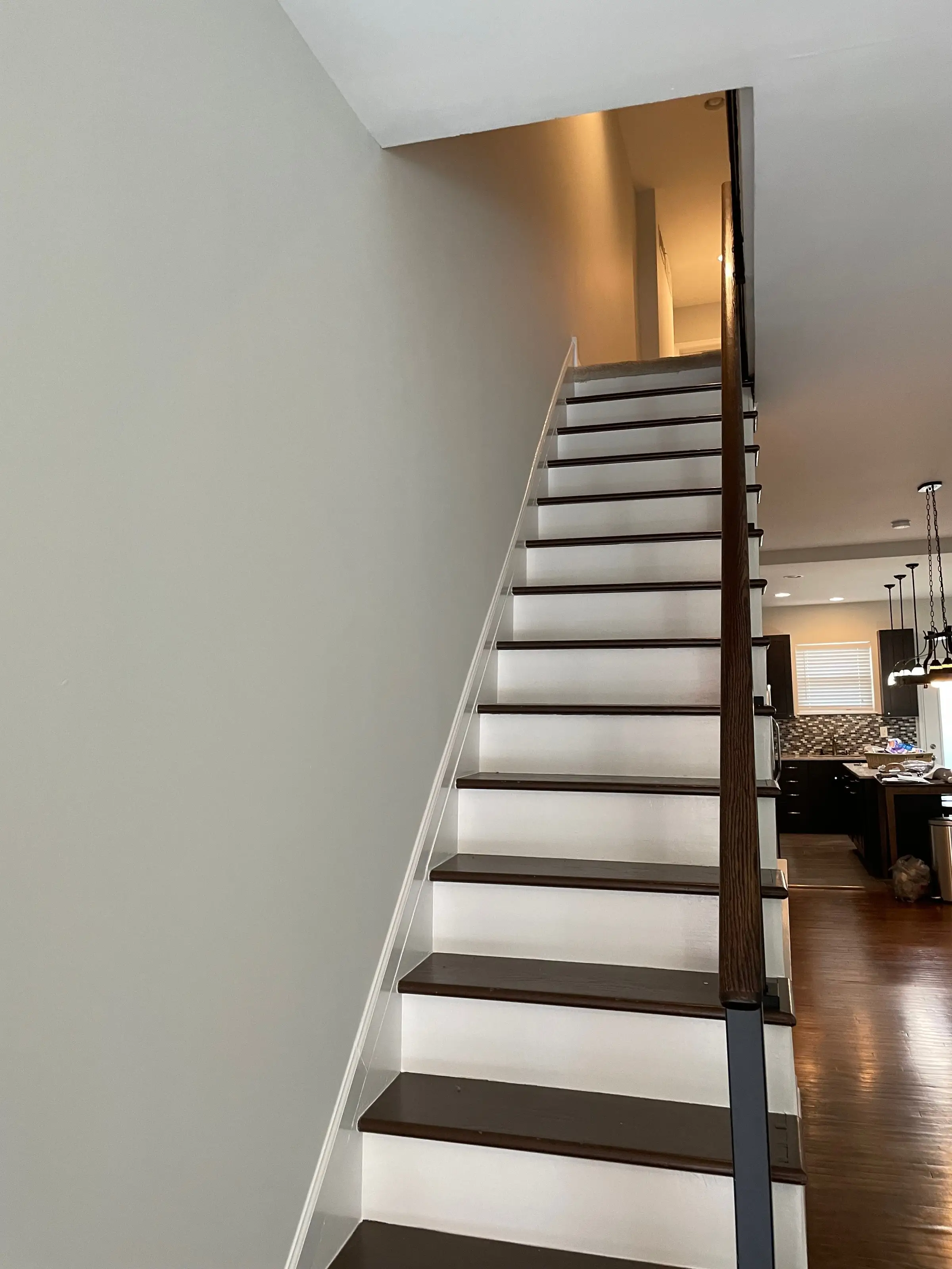 Staircase with white painted balusters and dark treads